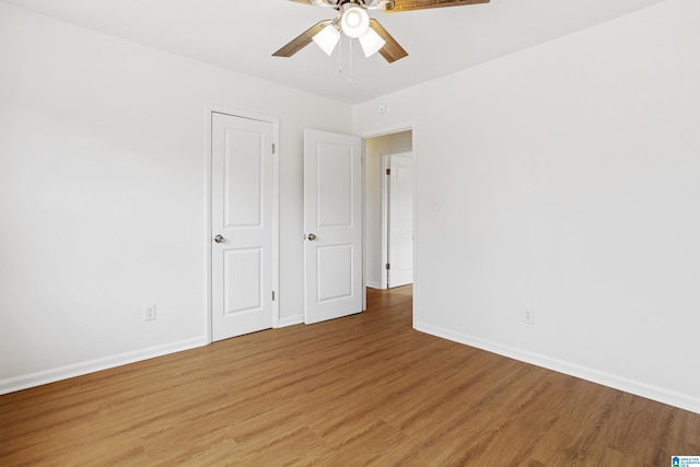 unfurnished room featuring light wood-type flooring, baseboards, and a ceiling fan