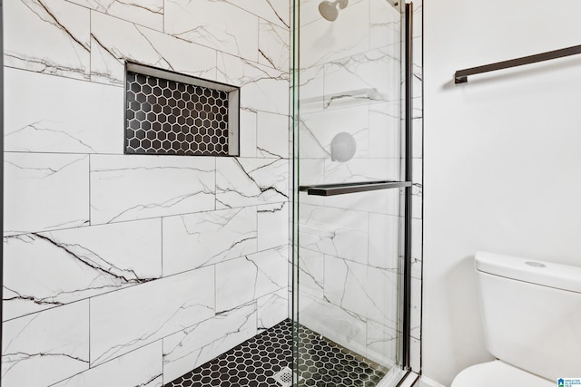 bathroom with a shower stall and toilet