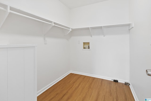 washroom featuring hookup for a washing machine, laundry area, baseboards, and wood finished floors