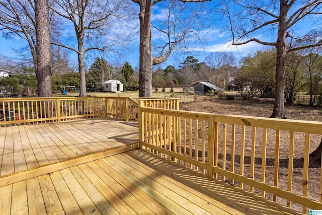 wooden deck with a storage shed and an outdoor structure