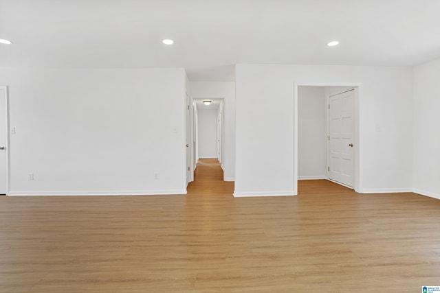 spare room with recessed lighting, baseboards, and light wood finished floors