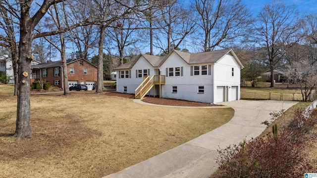 view of front facade with concrete driveway, a chimney, stairway, an attached garage, and a front lawn