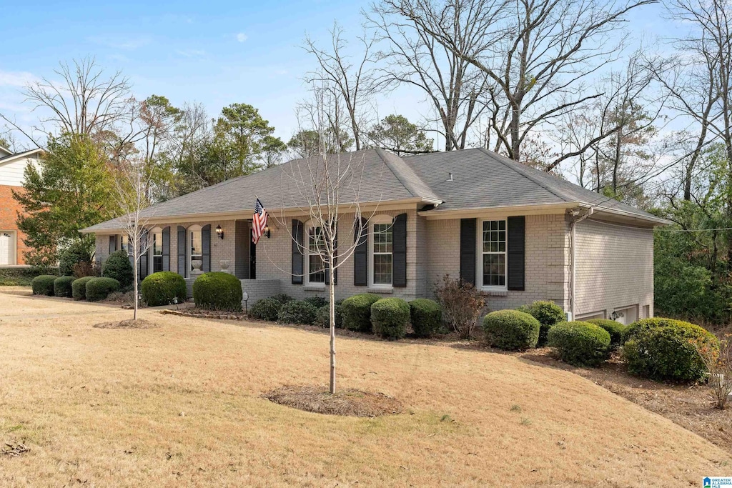 ranch-style home featuring brick siding and a front lawn