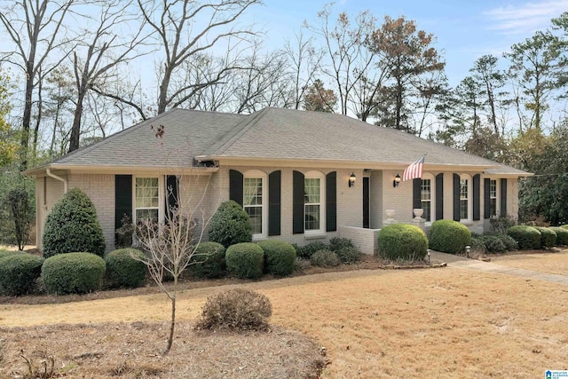 single story home featuring roof with shingles, a porch, and brick siding