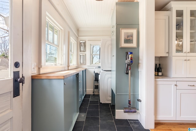 kitchen with white cabinetry, crown molding, and glass insert cabinets