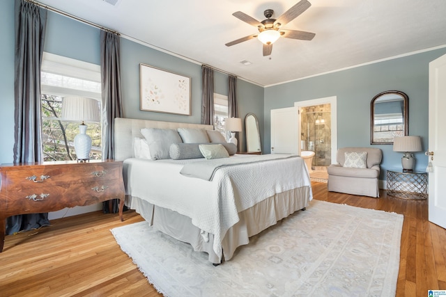 bedroom with multiple windows, crown molding, and wood finished floors