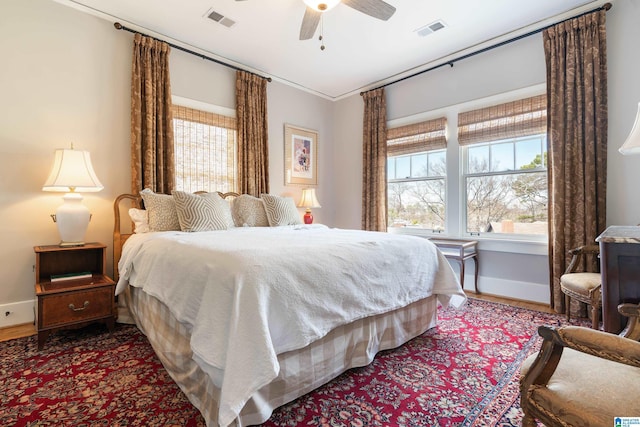 bedroom with visible vents, baseboards, and wood finished floors