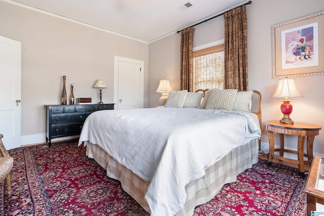 bedroom featuring visible vents, crown molding, and baseboards