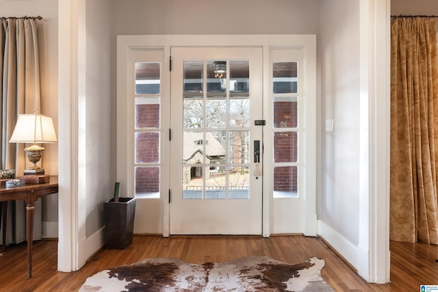 doorway to outside with wood finished floors and baseboards