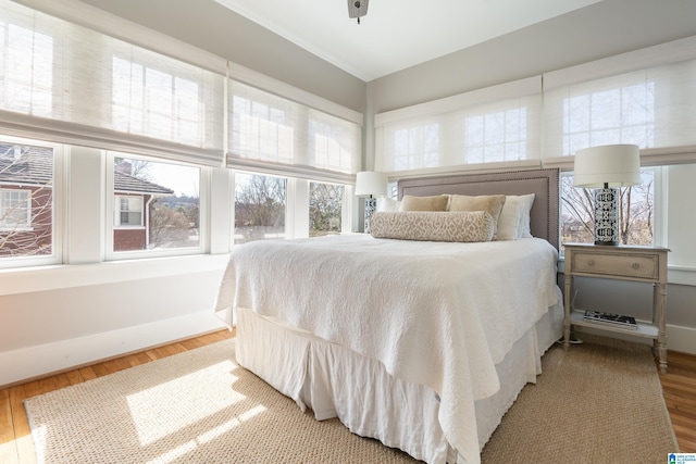 bedroom with light wood-style flooring and baseboards