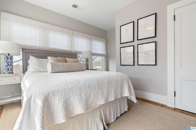 bedroom with visible vents, baseboards, and light wood-style floors