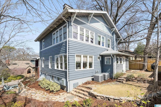 exterior space featuring central AC and fence