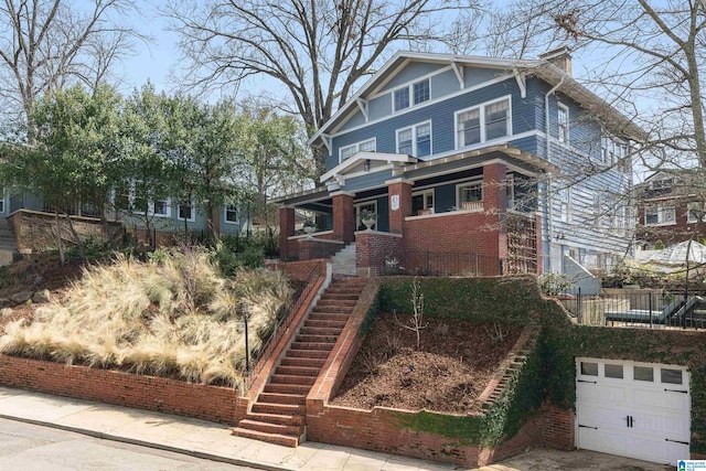 view of front of home with stairway, brick siding, a chimney, and fence