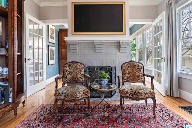 sitting room with visible vents, crown molding, baseboards, french doors, and wood finished floors