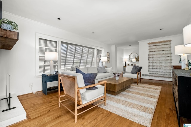 living area with visible vents, wood finished floors, and crown molding