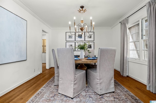 dining area featuring an inviting chandelier, wood finished floors, and ornamental molding