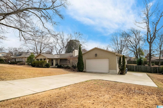 ranch-style home with a front yard, fence, a chimney, concrete driveway, and a garage