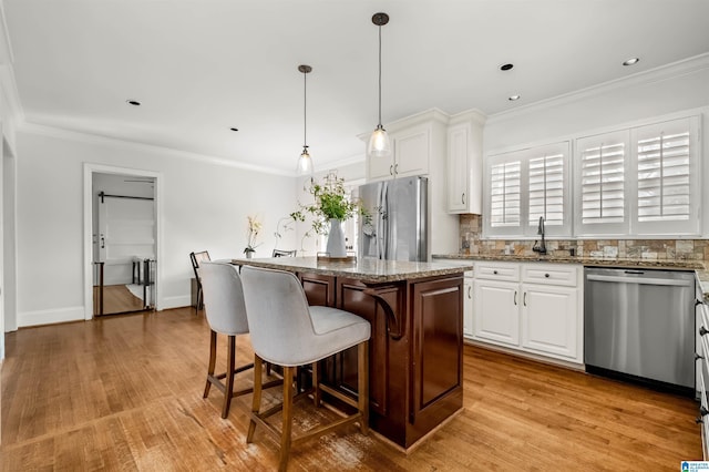 kitchen with a center island, decorative backsplash, ornamental molding, and stainless steel appliances