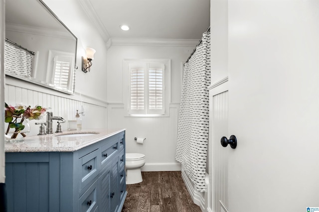 bathroom featuring vanity, wood finished floors, a wainscoted wall, ornamental molding, and toilet