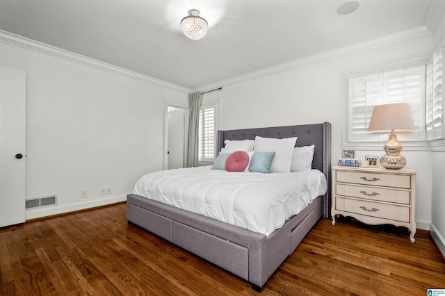 bedroom featuring crown molding, wood finished floors, and visible vents