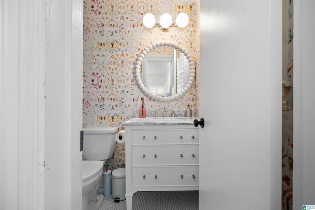 bathroom with wallpapered walls, tile patterned floors, toilet, and vanity