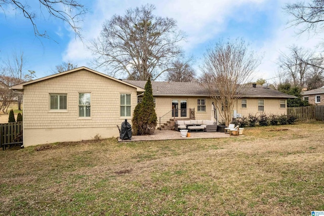 rear view of house with a patio area, an outdoor living space, a yard, and fence