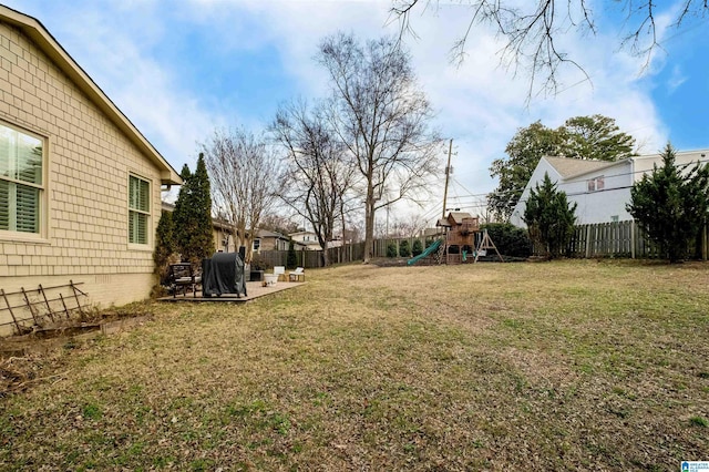 view of yard featuring a patio, a fenced backyard, and a playground