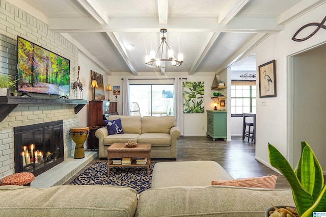 living room with baseboards, lofted ceiling with beams, wood finished floors, a fireplace, and a notable chandelier