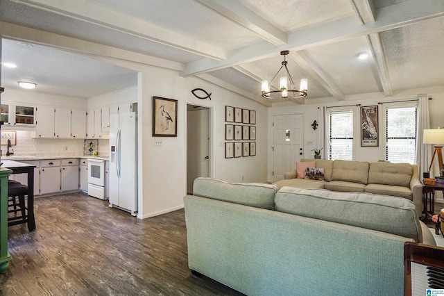 living area featuring dark wood finished floors, lofted ceiling with beams, a textured ceiling, a chandelier, and baseboards