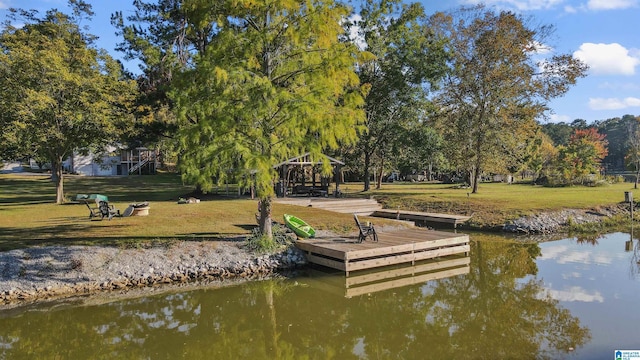 dock area with a gazebo, a yard, and a water view