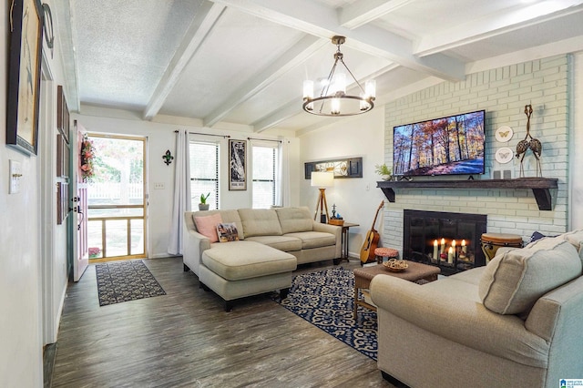 living area featuring lofted ceiling with beams, a textured ceiling, a chandelier, wood finished floors, and a brick fireplace