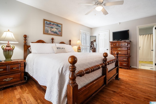 bedroom with a ceiling fan, wood finished floors, ensuite bathroom, a textured ceiling, and a closet