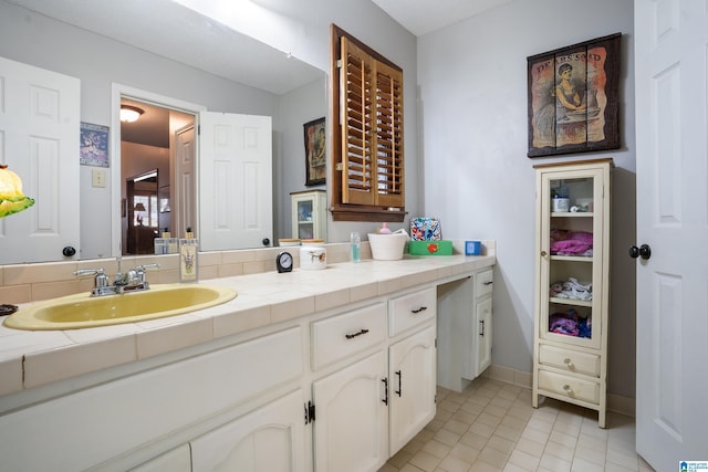 bathroom featuring tile patterned floors, baseboards, and vanity