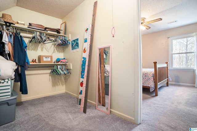 spacious closet with carpet floors, lofted ceiling, visible vents, and a ceiling fan