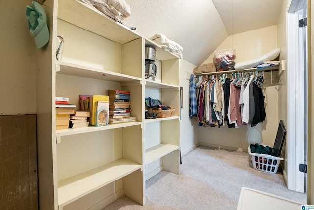 walk in closet with carpet floors and vaulted ceiling