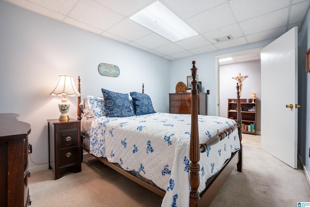 bedroom with carpet floors, a paneled ceiling, and visible vents