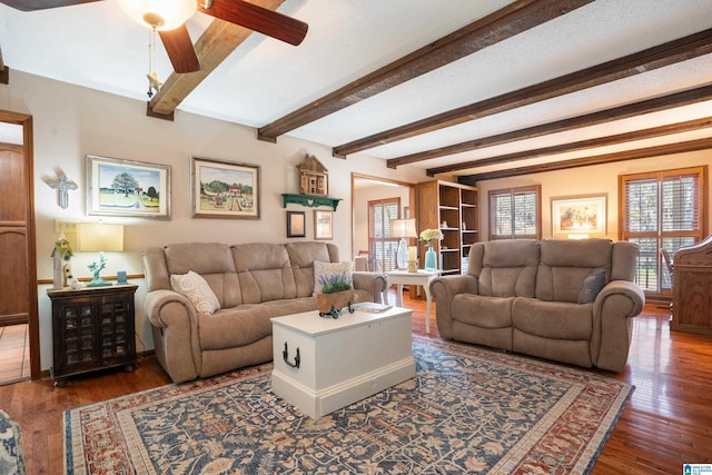 living area featuring ceiling fan, beamed ceiling, and wood finished floors