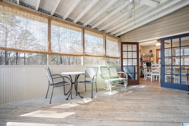 sunroom / solarium with lofted ceiling, plenty of natural light, and a ceiling fan