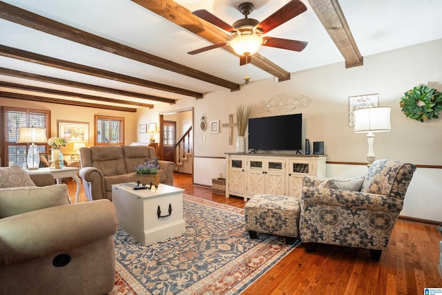 living room featuring stairs, wood finished floors, beam ceiling, and a ceiling fan