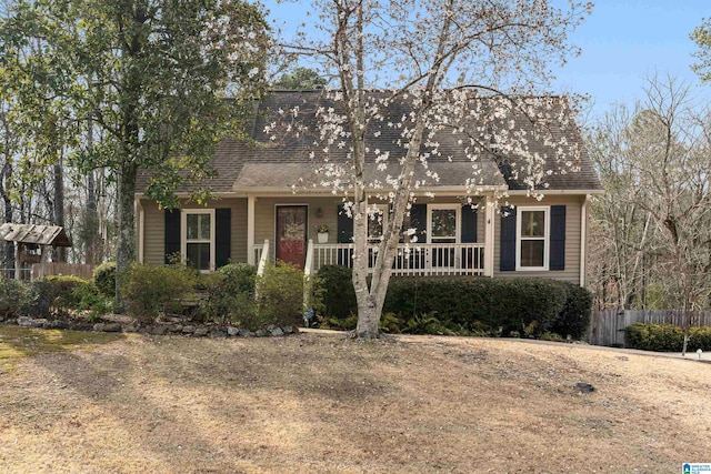 view of front of home featuring covered porch, roof with shingles, and fence