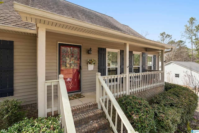 property entrance with a shingled roof and covered porch