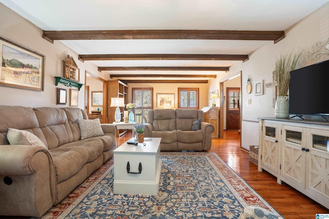 living area featuring beamed ceiling and wood finished floors