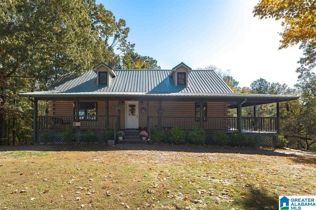 log cabin with metal roof, a porch, log exterior, and a front yard