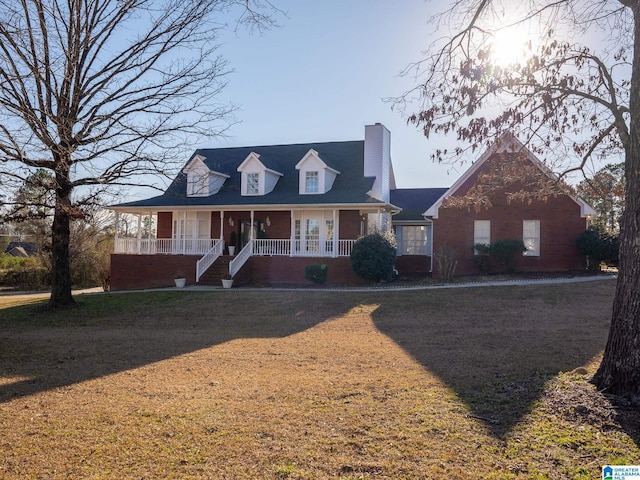 view of front of house featuring a chimney, a porch, and brick siding