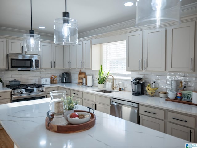 kitchen featuring crown molding, appliances with stainless steel finishes, decorative backsplash, and a sink