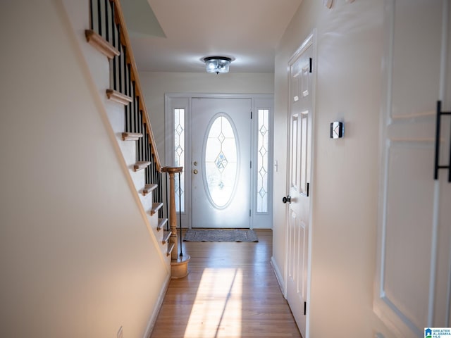 doorway featuring stairway and wood finished floors