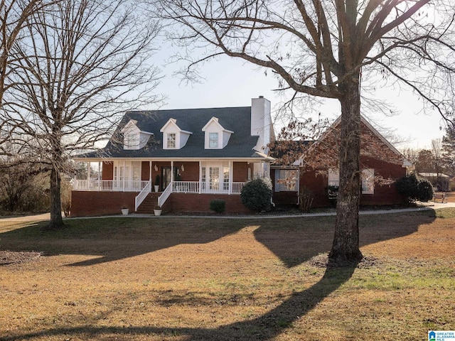 cape cod-style house with covered porch, brick siding, a chimney, and a front lawn