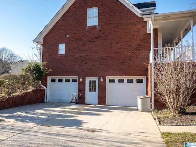 view of home's exterior featuring a garage, driveway, and brick siding