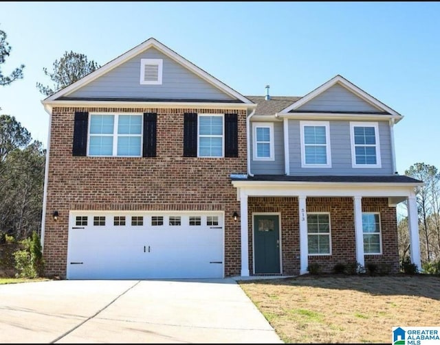 view of front of home with brick siding, a front yard, covered porch, a garage, and driveway