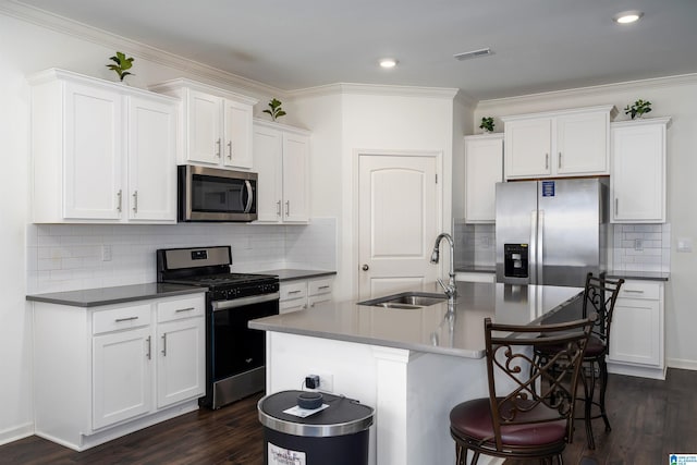 kitchen with visible vents, dark wood-style flooring, a sink, appliances with stainless steel finishes, and a kitchen bar